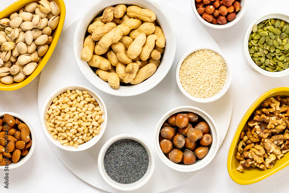 Various Nuts and Seeds on White Background in the Bowls - Image Various Nuts and Seeds on White Background in the Bowls - Image
