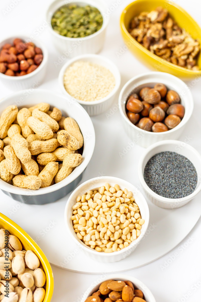 Various Nuts and Seeds on White Background in the Bowls - Image Various Nuts and Seeds on White Background in the Bowls - Image