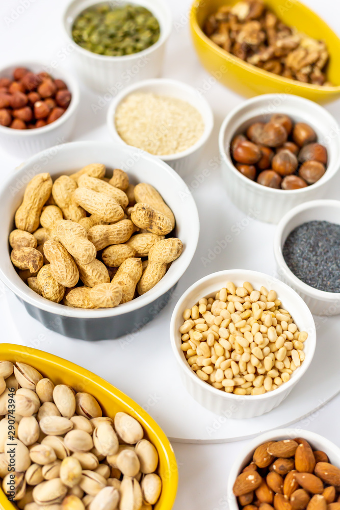 Various Nuts and Seeds on White Background in the Bowls - Image Various Nuts and Seeds on White Background in the Bowls - Image