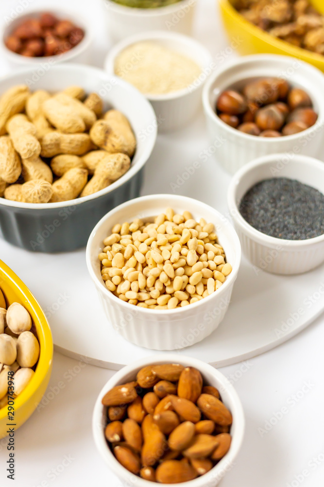 Various Nuts and Seeds on White Background in the Bowls - Image Various Nuts and Seeds on White Background in the Bowls - Image