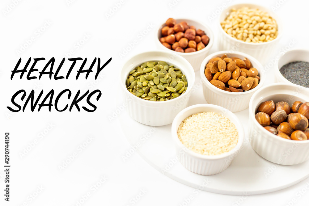 Top View of Variety of Nuts and Seeds on the White Background with Healthy Snacks Text Copy Top View of Variety of Nuts and Seeds on the White Background with Healthy Snacks Text Copy