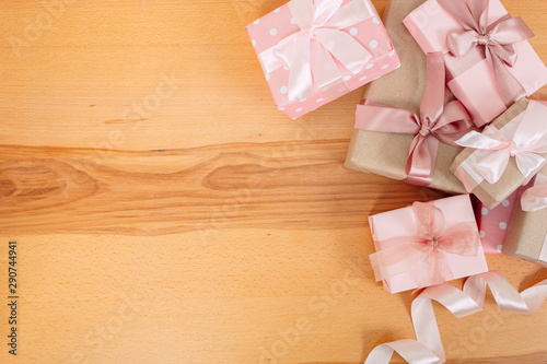 Set of beautiful gift boxes with pink bows on a wooden table. top view. flat lay
