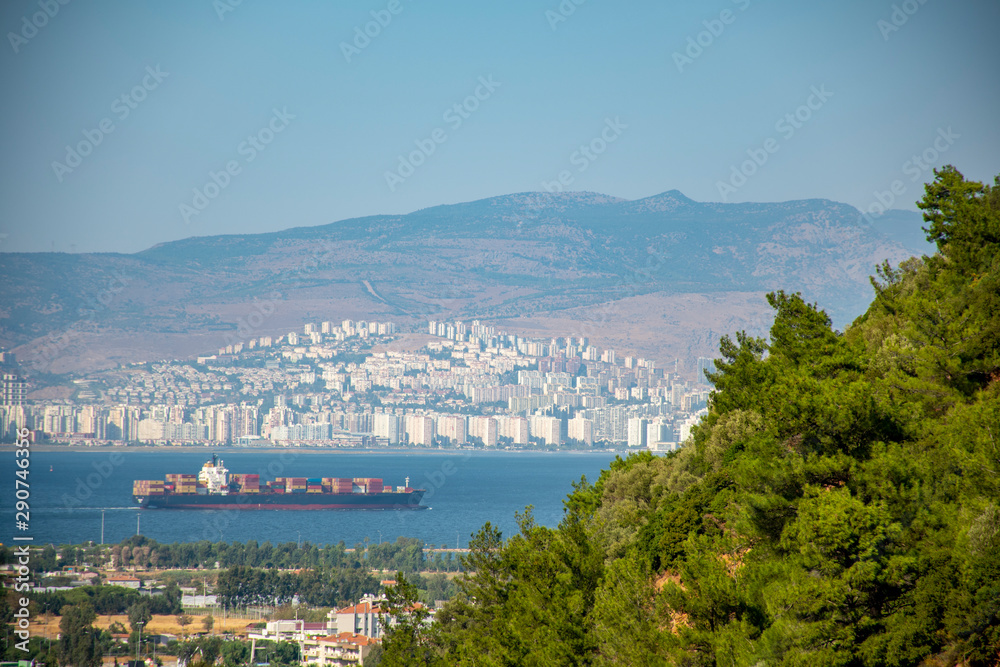 cargo ship in the gulf of izmir.  landscape with trees