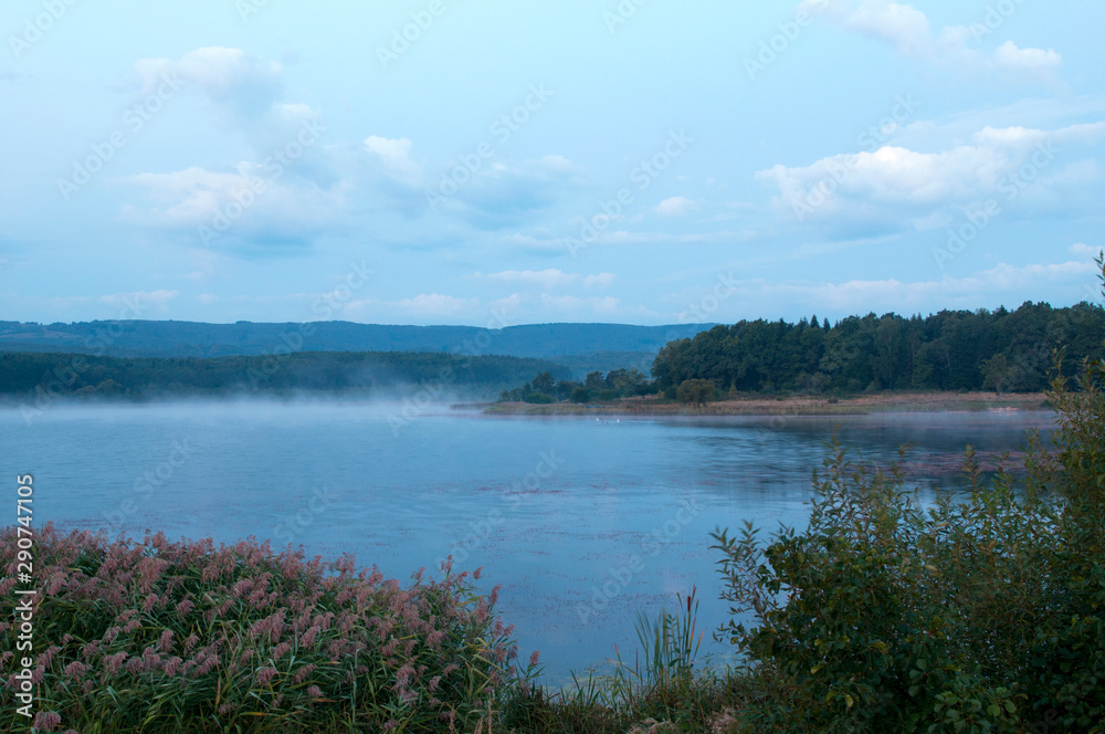 colorful moon on autumn lake at dawn with forest