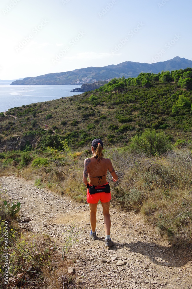 Fototapeta premium jeune coureuse de course à pied en trekking sur un sentier en bord de mer