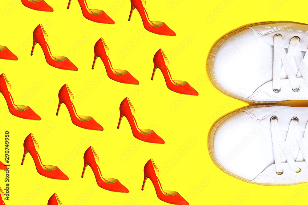 White sneakers against female red shoes on yellow. White sneakers against female red shoes on yellow.