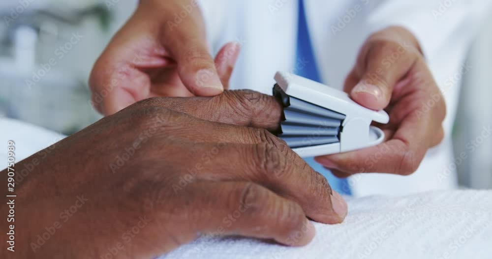 Closeup of African american female doctor attaching pulse oximetry on