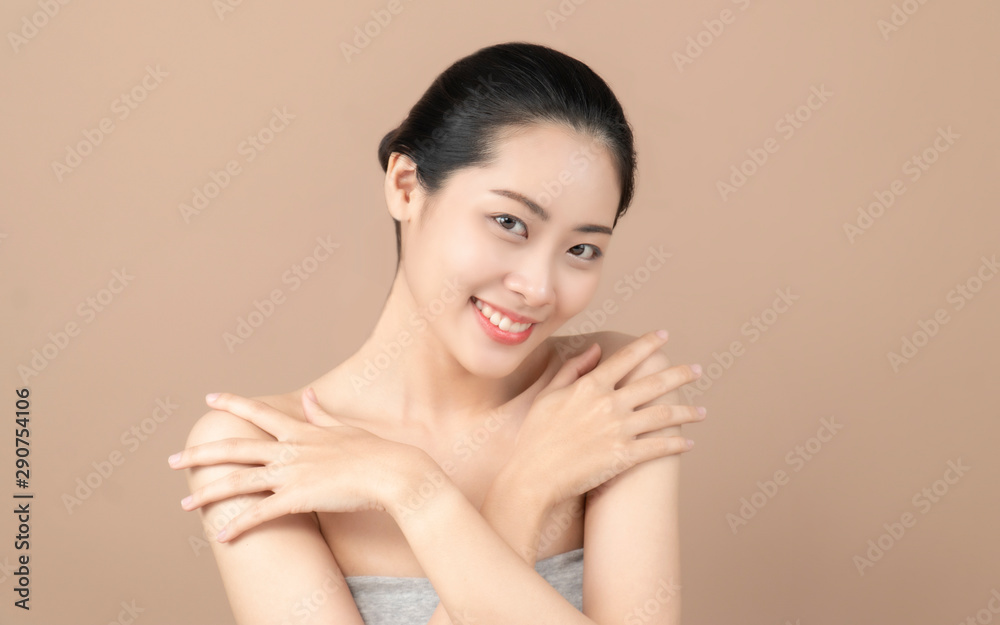 Asian woman smiling and touching her face. Skincare and Cosmetology concept. beige background Asian woman smiling and touching her face. Skincare and Cosmetology concept. beige background