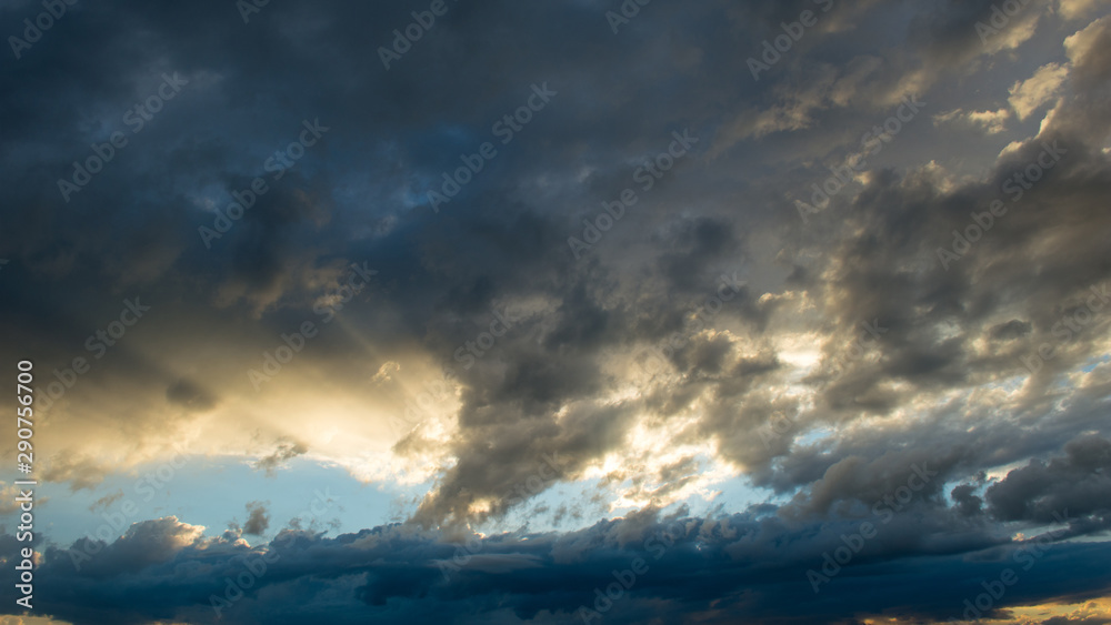 Sunbeam over storm clouds at sunset