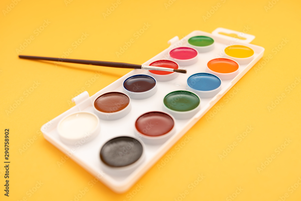 watercolor paints in box on yellow background watercolor paints in box on yellow background