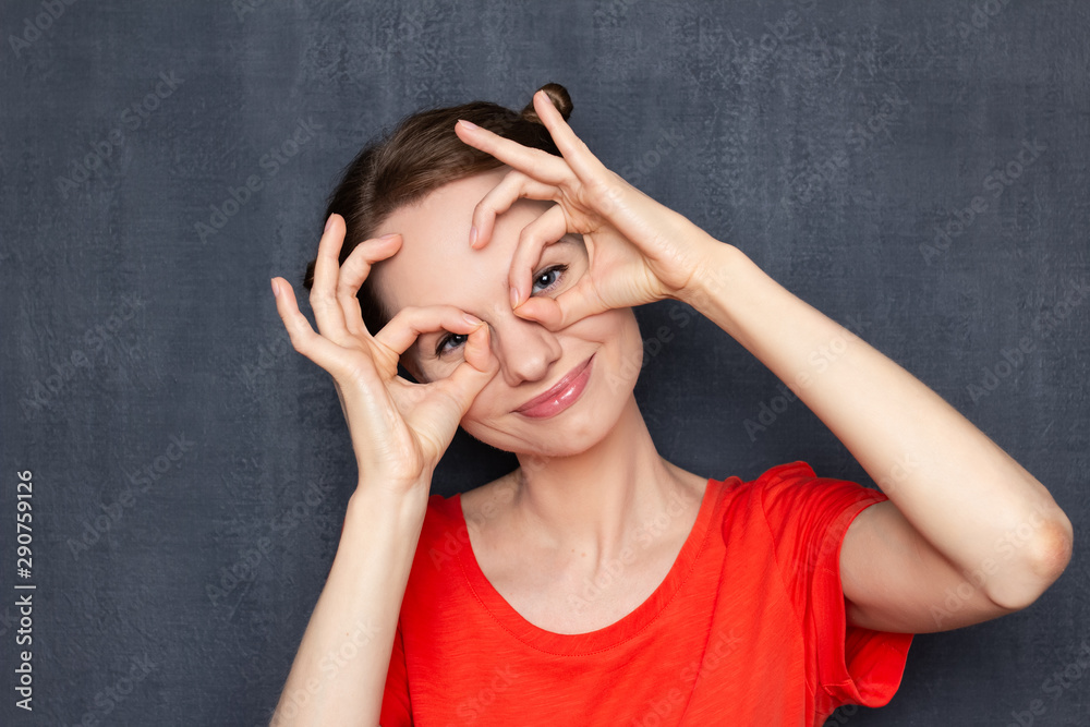 Portrait of happy young woman making glasses shape with hands Portrait of happy young woman making glasses shape with hands