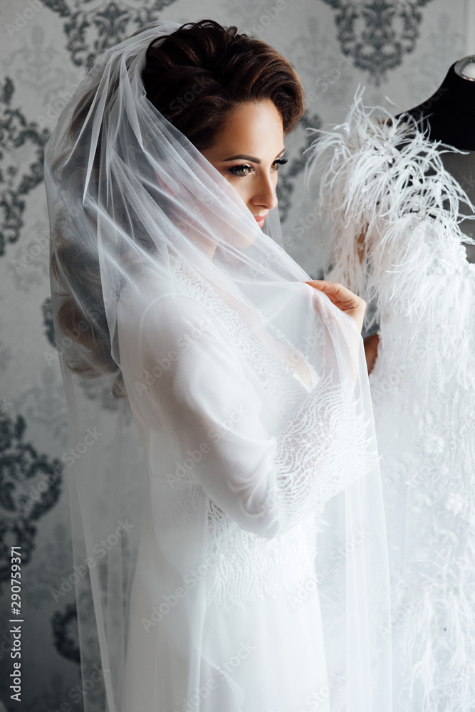 Morning of beautiful bride near the wedding dress. Bride in a white ...
