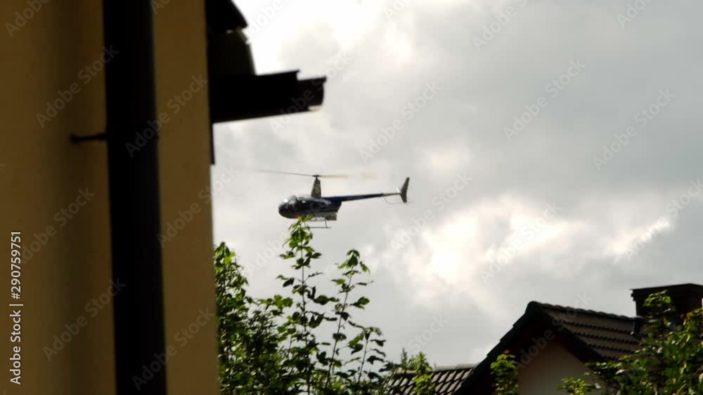 A helicopter flying above the buildings through a cloudy sky. A helicopter flying above the buildings through a cloudy sky.