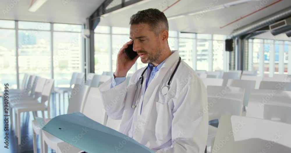 Doctor talking on smartphone at a seminar Doctor talking on smartphone at a seminar