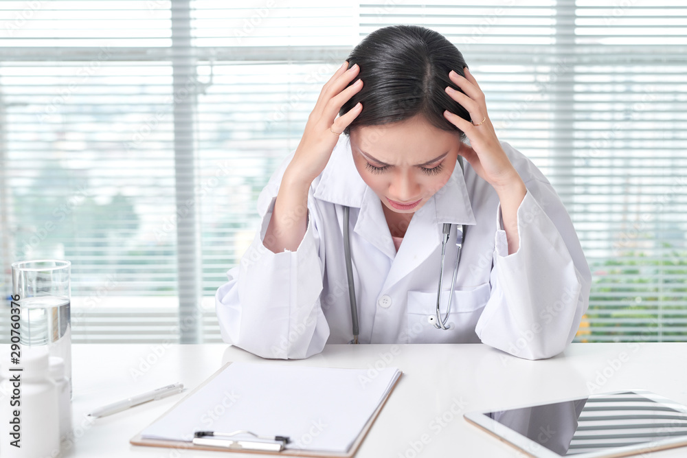 Doctor has a headache sitting at the desk. Doctor has a headache sitting at the desk.