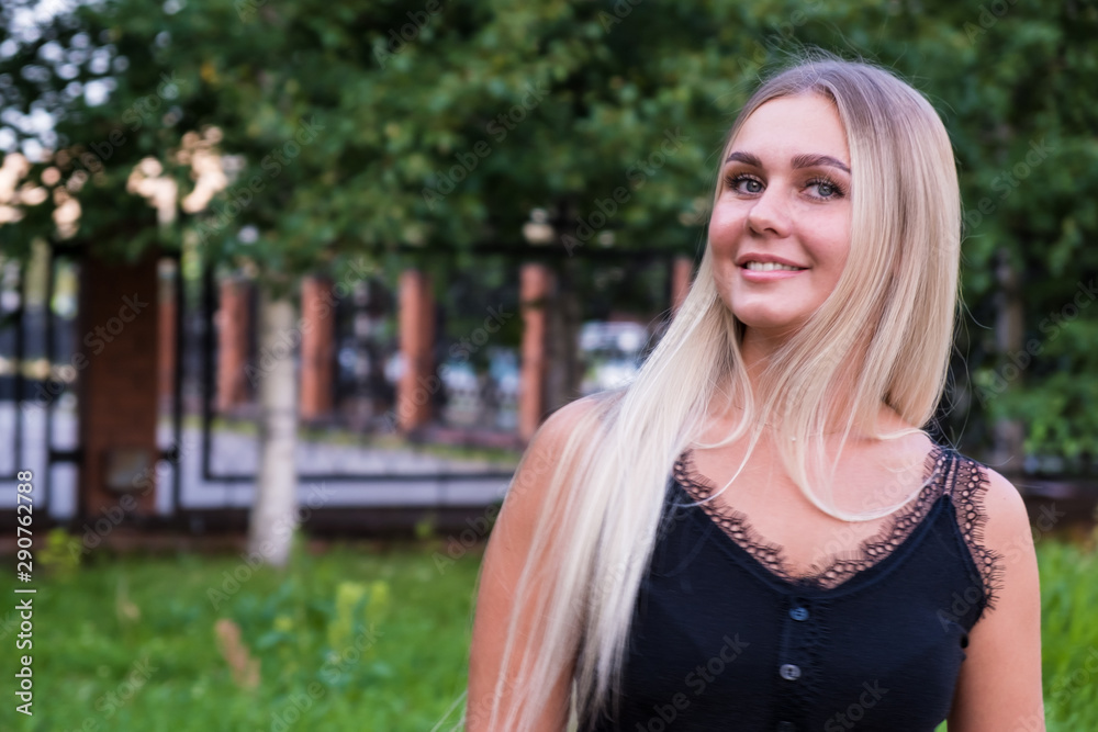 Portrait of a beautiful young woman with long shiny blond hair looking at the camera. Hair care concept. Portrait of a beautiful young woman with long shiny blond hair looking at the camera. Hair care concept.