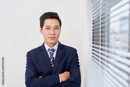 Smiling man standing near big white plastic window