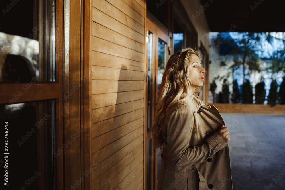 a girl stands sideway near a wall and looks into the distance a girl stands sideway near a wall and looks into the distance