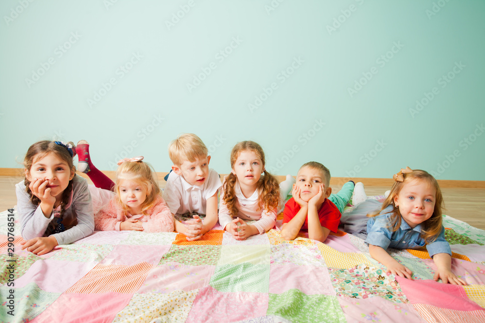 Children watching TV laying on a floor