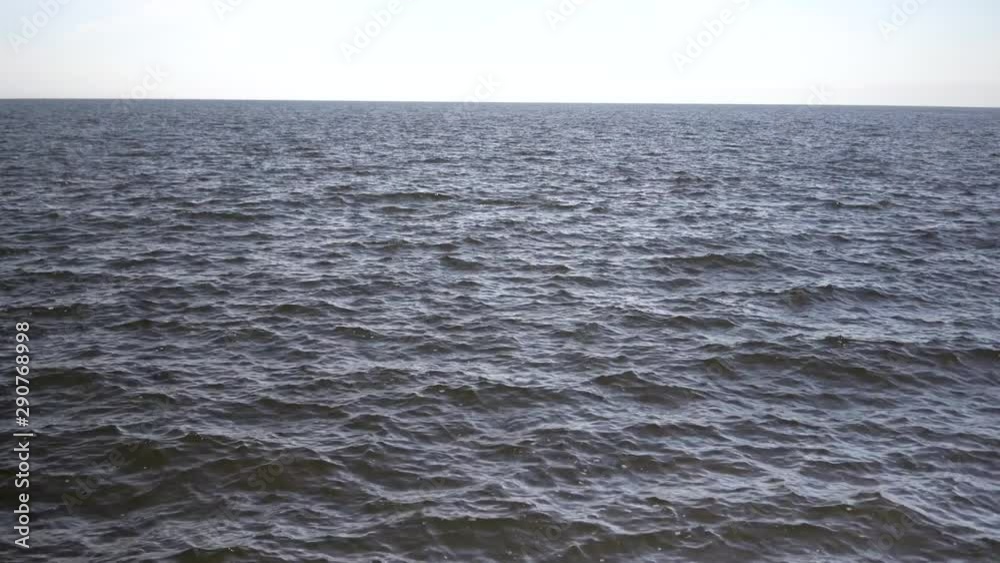 Baltic Sea skyline with clear sky and small wave at sunset in summer. Latvia