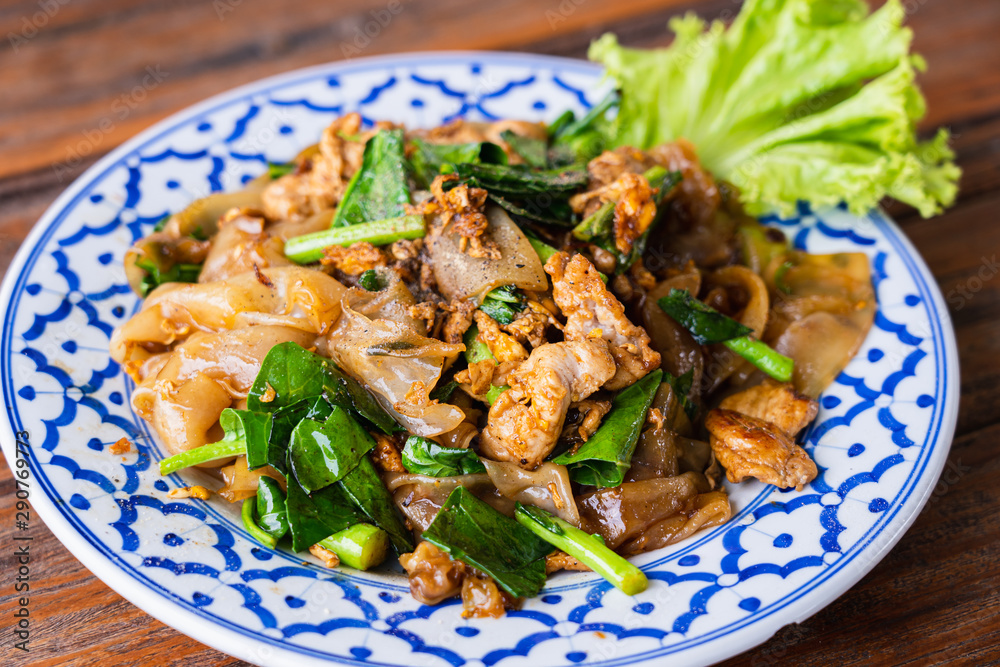 Fried Noodle in Soy Sauce in beautiful dish on wooden table, special Thai food in Thailand Fried Noodle in Soy Sauce in beautiful dish on wooden table, special Thai food in Thailand