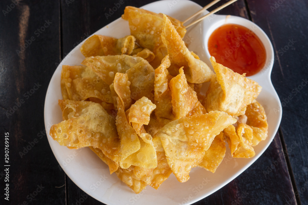 Close up deep fried pork wonton or giew moo with dipping sauce.