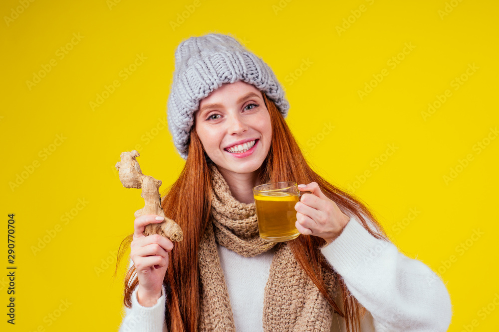 sick illness redhaired woman good looking wearing knitted sweater and hat with scarf drinking hot tea cup with lemon and ginger in studio yellow background. sick illness redhaired woman good looking wearing knitted sweater and hat with scarf drinking hot tea cup with lemon and ginger in studio yellow background.