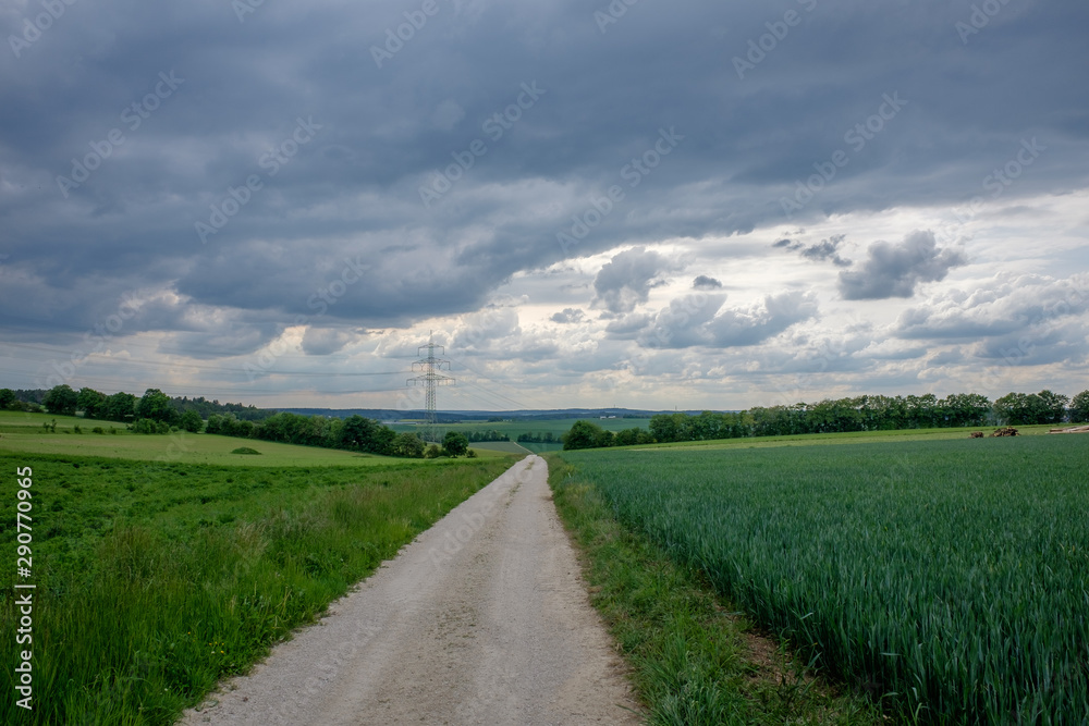 Feldweg unter schweren Juli-Wolken