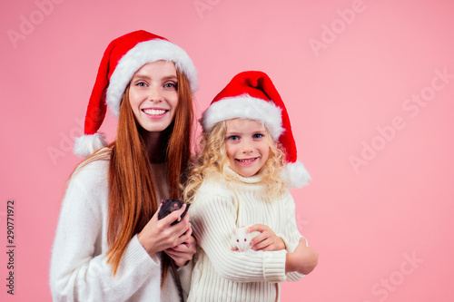 girls in red santa hat holding cute black rat in studio pink background.two thousand and twentieth year symbol