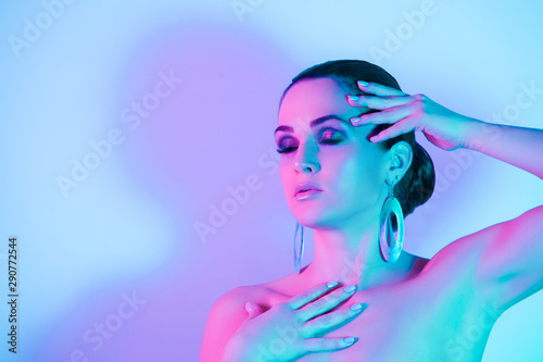 Woman in neon colorful lights, eyes closed