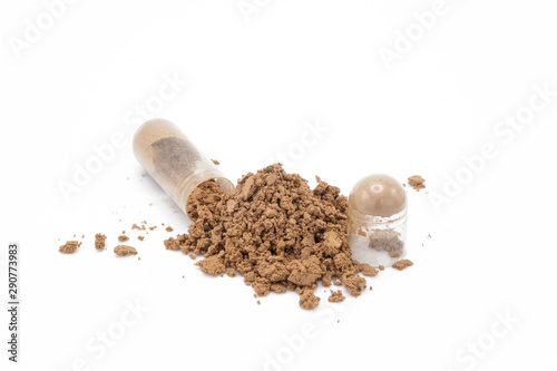 Capsule of medicine and the powder that has been poured out on white background