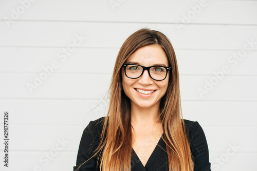 Close up portrait of beautiful young businesswoman wearing eyeglasses photo