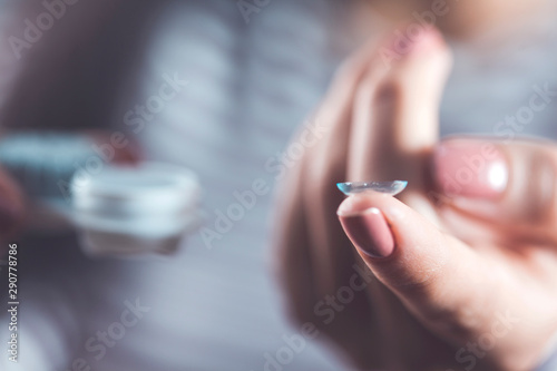 Woman holding contact lens
