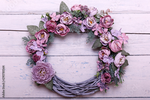 Door wreath made of artificial flowers and autumn plants on shabi white wooden background. photo