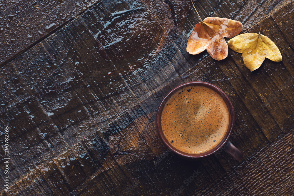 Cup of black coffee and autumn leaves on old wet wooden table. Flat lay Cup of black coffee and autumn leaves on old wet wooden table. Flat lay