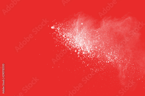 Explosion of colored powder on redbackground