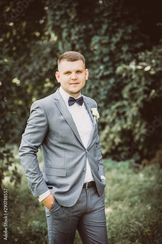 Handsome groom in suit and bow-tie, tinted