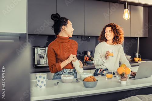 Happy girls cooking breakfast together in the kitchen photo