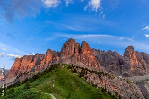 A stunning sunset view of the Dolomites Alps painted red from the setting sun. (View from a top place for shooting sunset in the Dolomites) Italian Dolomites, Alto Adige, Colfosco.