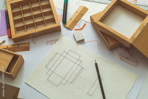 Development design drawing packaging. Desktop of a creative person making cardboard boxes. photo