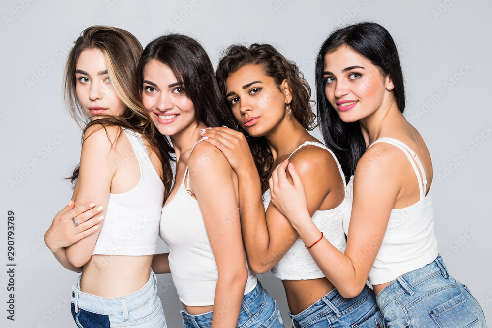 Full length portrait of a four happy women hug each other standing isolated on a white background Full length portrait of a four happy women hug each other standing isolated on a white background