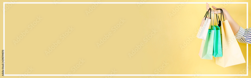 web banner mid season sale and shopping activity from hand hold the shopping bag with copy space and yellow vintage background