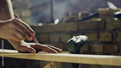hand of a carpenter taking measurement of a wooden plank 4K