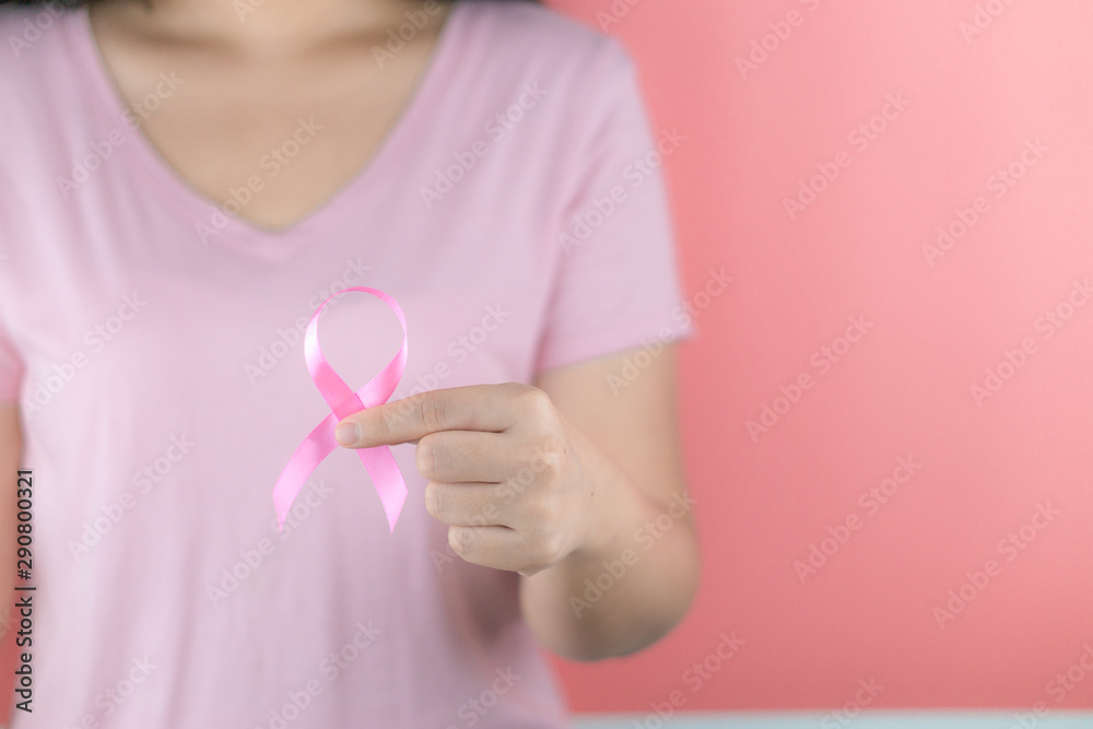 Healthcare, medicine and breast cancer awareness concept. Closeup on woman chest with pink breast cancer awareness ribbon. Healthcare, medicine and breast cancer awareness concept. Closeup on woman chest with pink breast cancer awareness ribbon.