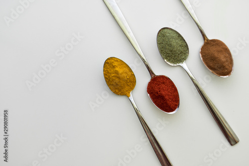 Various colorful spices arranged on spoons