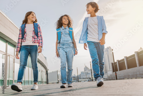Full length shot of multiethnic group elementary school kids walking to school outdoor photo