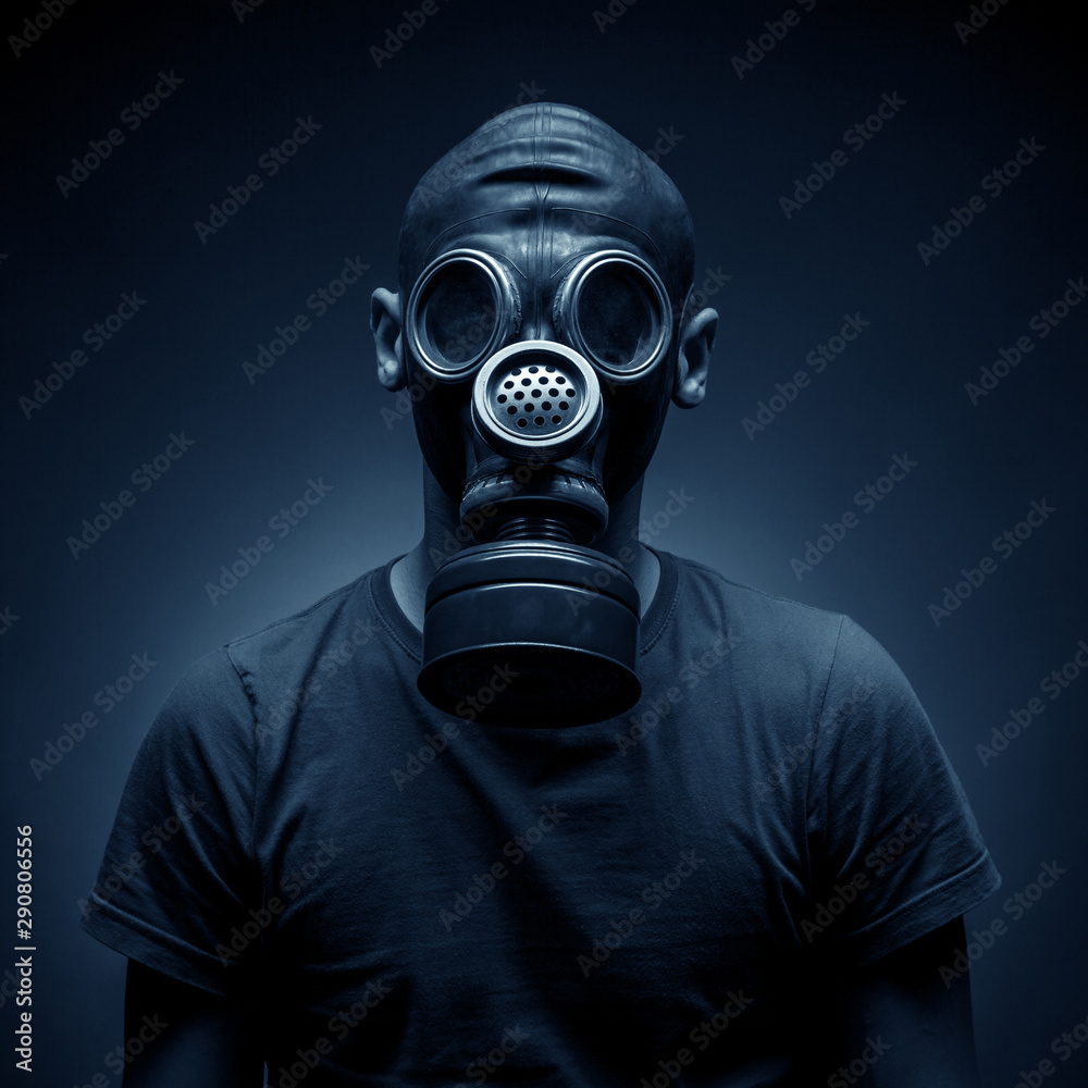 Young man in a gas mask against a dark background Young man in a gas mask against a dark background
