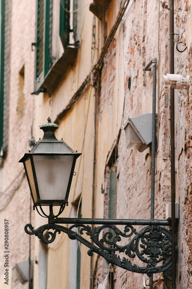 Italy, Tuscany, Lucca:- Old street lamp in an alley of Lucca.