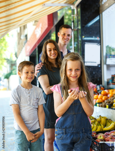 girl looking for fresh cherry during family shopping