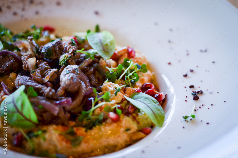 lebanese hummus dish with fresh vegetables, beef meat & pomegranate seeds lebanese hummus dish with fresh vegetables, beef meat & pomegranate seeds